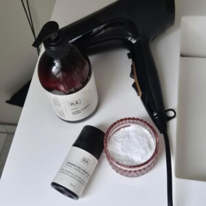 Ceramide fuktighetskrem fra RÅ Skincare for sensitiv hud på badet sammen med hårføner og toalettartikler.