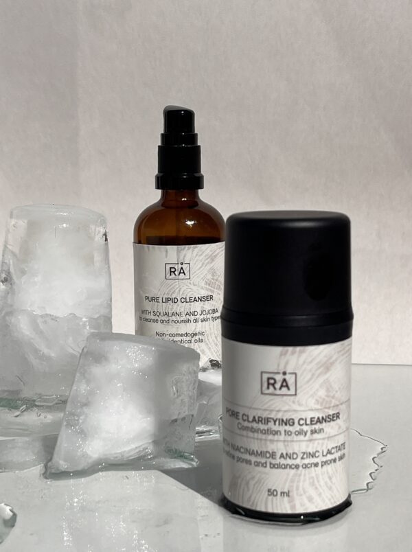 Pure Lipid Cleanser og Pore Clarifying Cleanser fra RÅ Skincare, presentert sammen som dobbelrens på lys bakgrunn med isbiter for en frisk følelse.