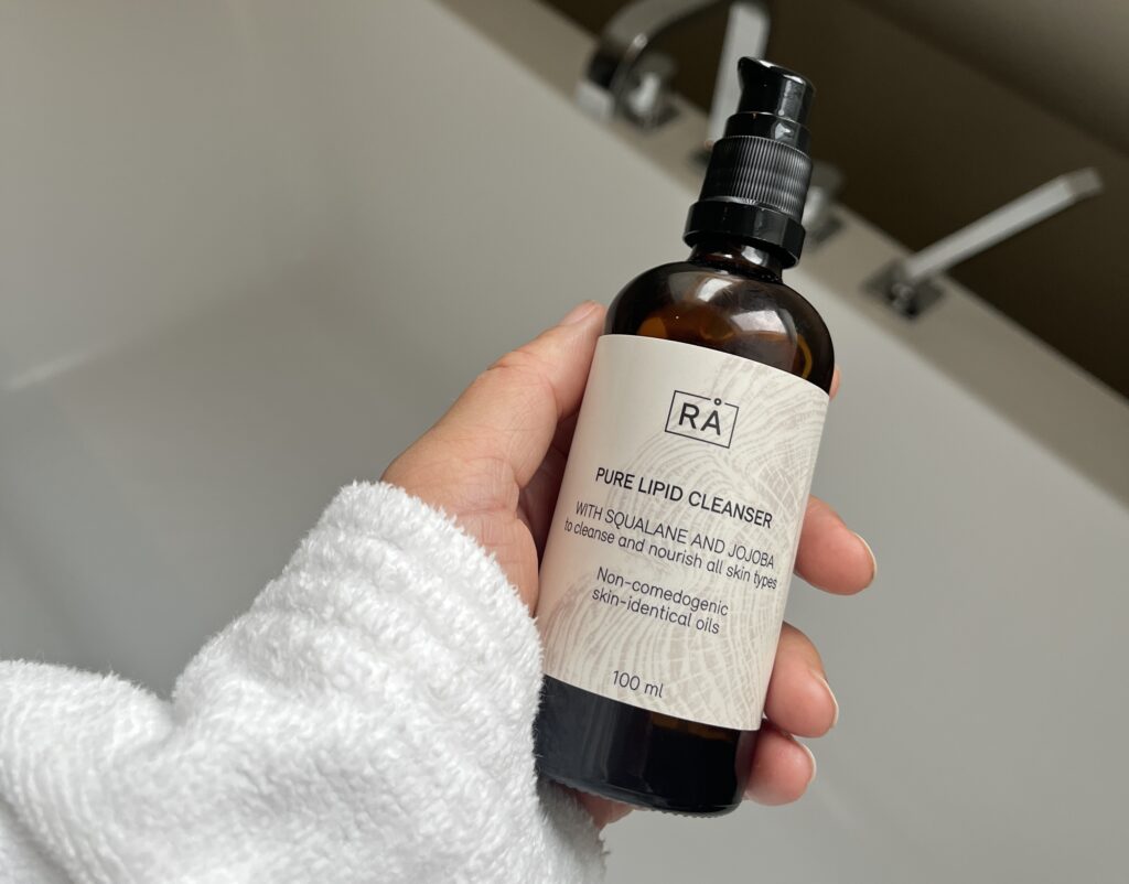 Bilde av hånd som holder rens for akne på badet