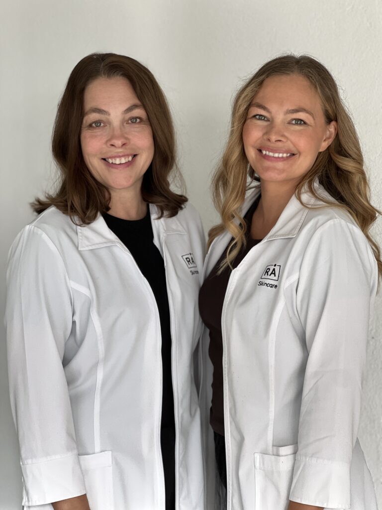 Torhild Næss og Amanda Næss Leonardsen i arbeidsuniform. Grunnleggerne av RÅ Skincare.